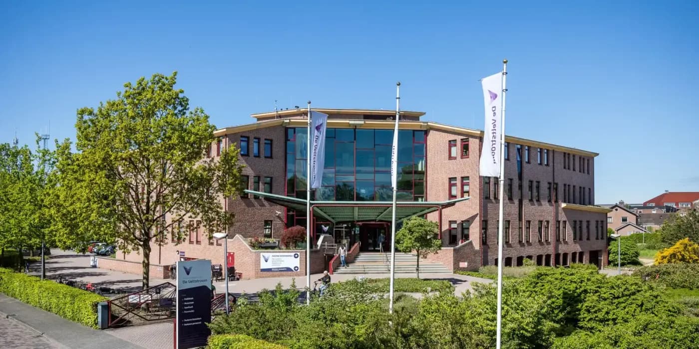 Gezondheidscentrum De Veltstroom in Coevorden, gezien vanaf de straat met vlaggen bij de ingang