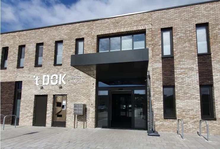 Ingang van 't Dok Medisch Centrum in Hellevoetsluis, een bakstenen gebouw met luifel