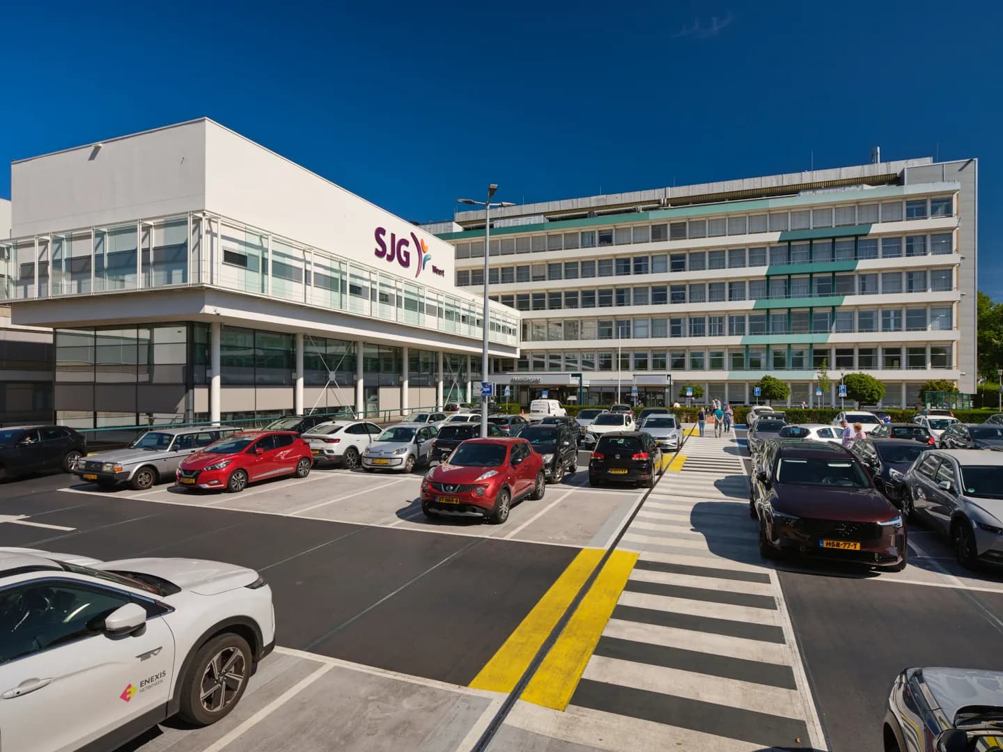 Nieuwbouw van SJG Weert met paars logo, gezien vanaf het parkeerdek