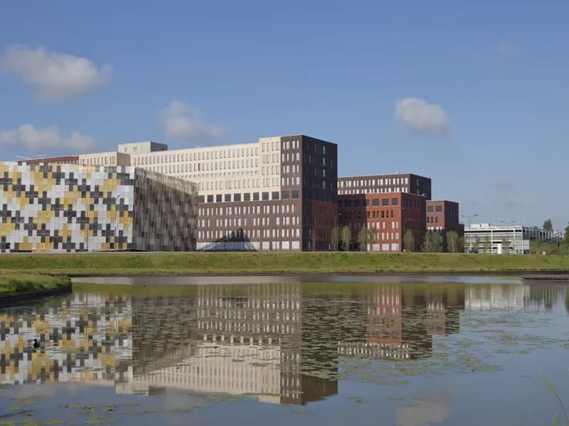 Het Jeroen Bosch Ziekenhuis in 's-Hertogenbosch gezien over het water, met de gekleurde gevel van de bezoekersgarage links