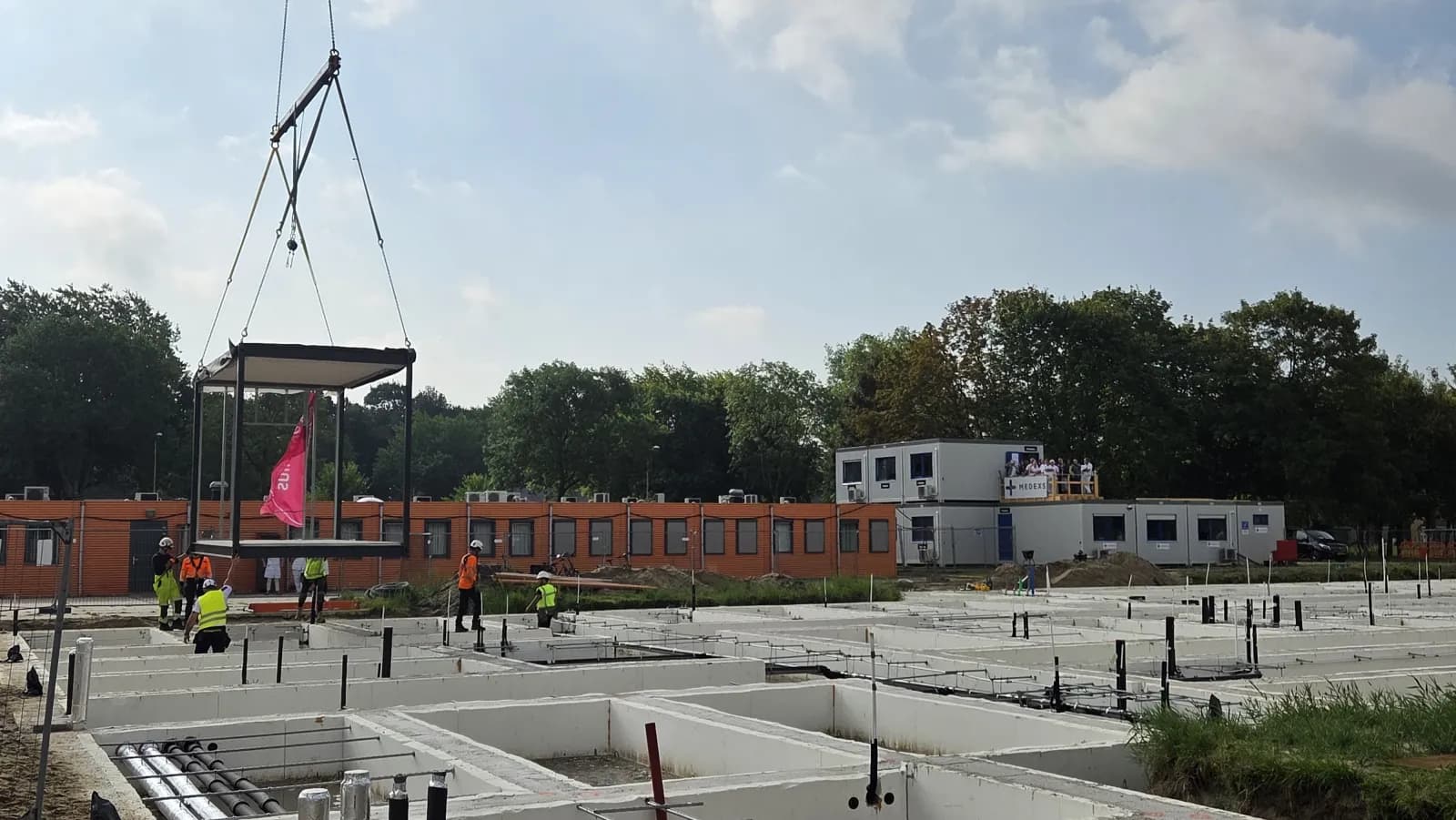 Bouw van het nieuwe zorggebouw aan de Urkerweg 4 in augustus 2026, met de huidige bebouwing op de achtergrond