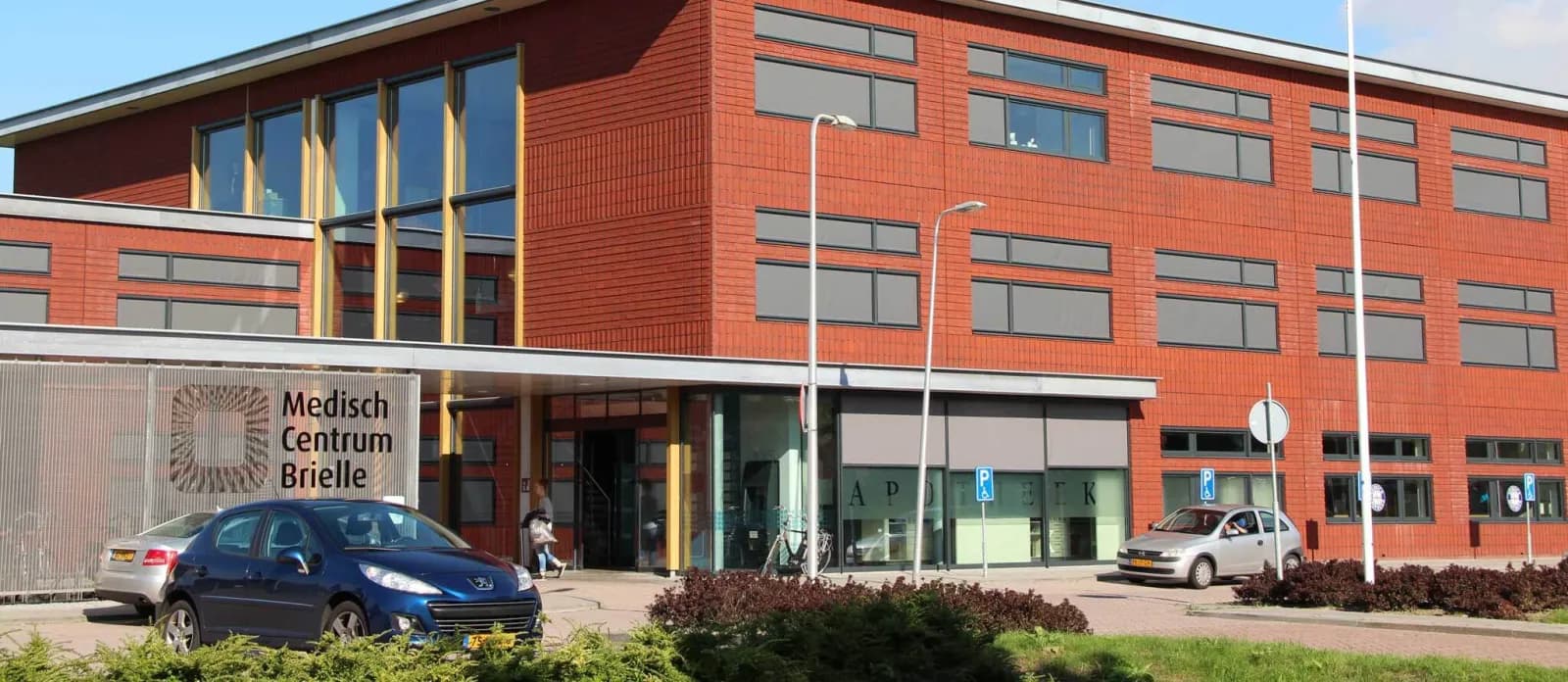 Medisch Centrum Brielle, een rood bakstenen gebouw met glazen ingang en parkeerplaatsen