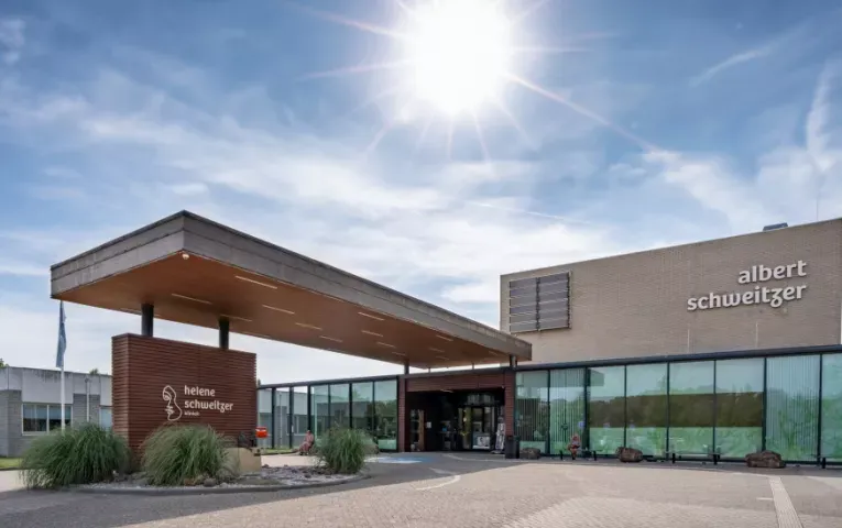 Hoofdingang van locatie Zwijndrecht met overkapping, het bord van de Helene Schweitzer kliniek en de gevelnaam albert schweitzer