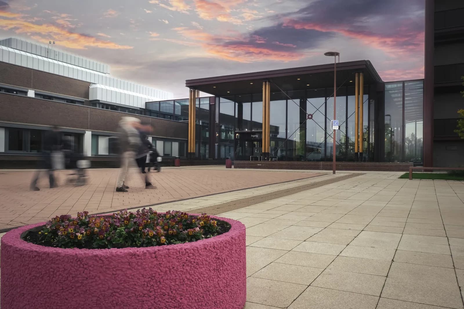 Hoofdingang van VieCuri in Venlo: glazen entreegebouw met een plein ervoor