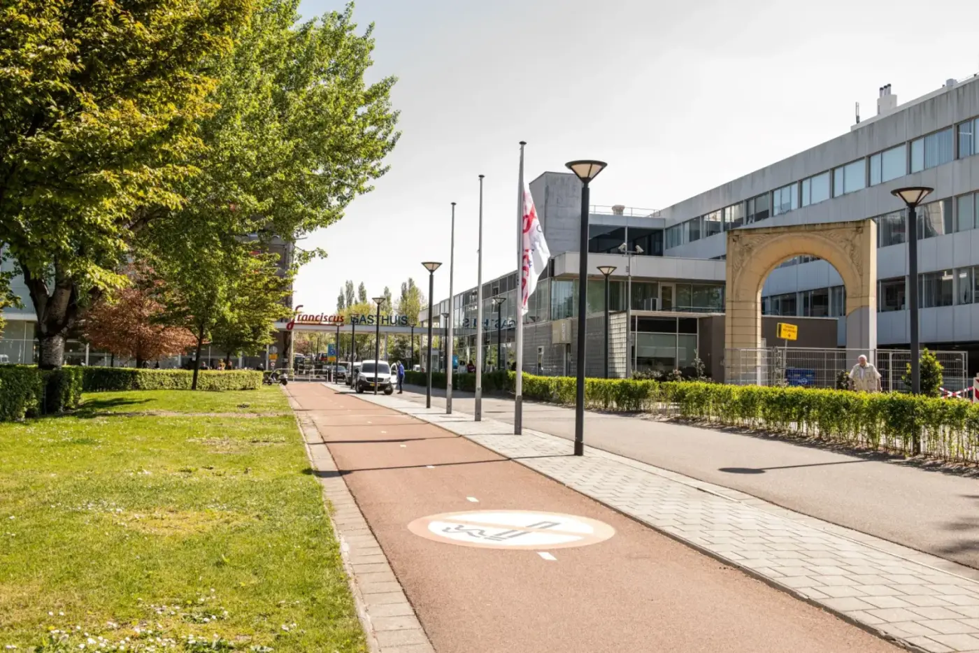 Voorterrein van Franciscus Gasthuis met fietspad, poort en het ziekenhuisgebouw